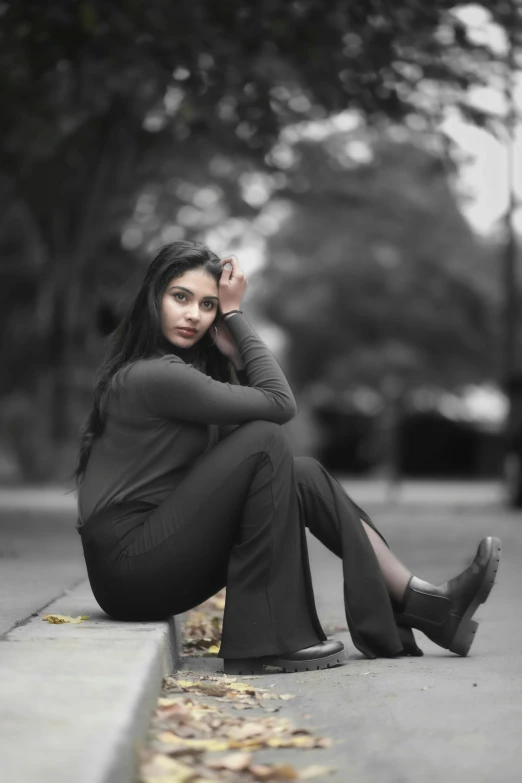 an attractive lady is sitting down on the side walk