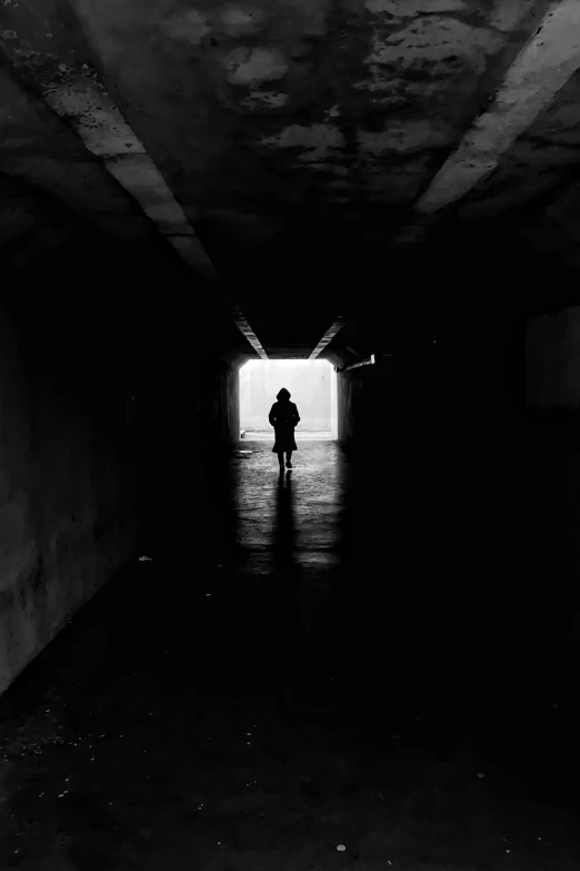 a person standing in an abandoned tunnel, facing the camera