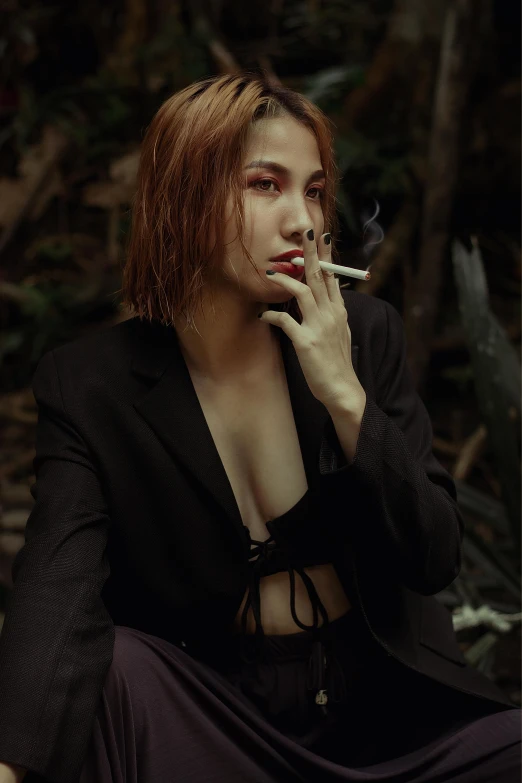 woman smoking cigarette while wearing black outfit and long skirt