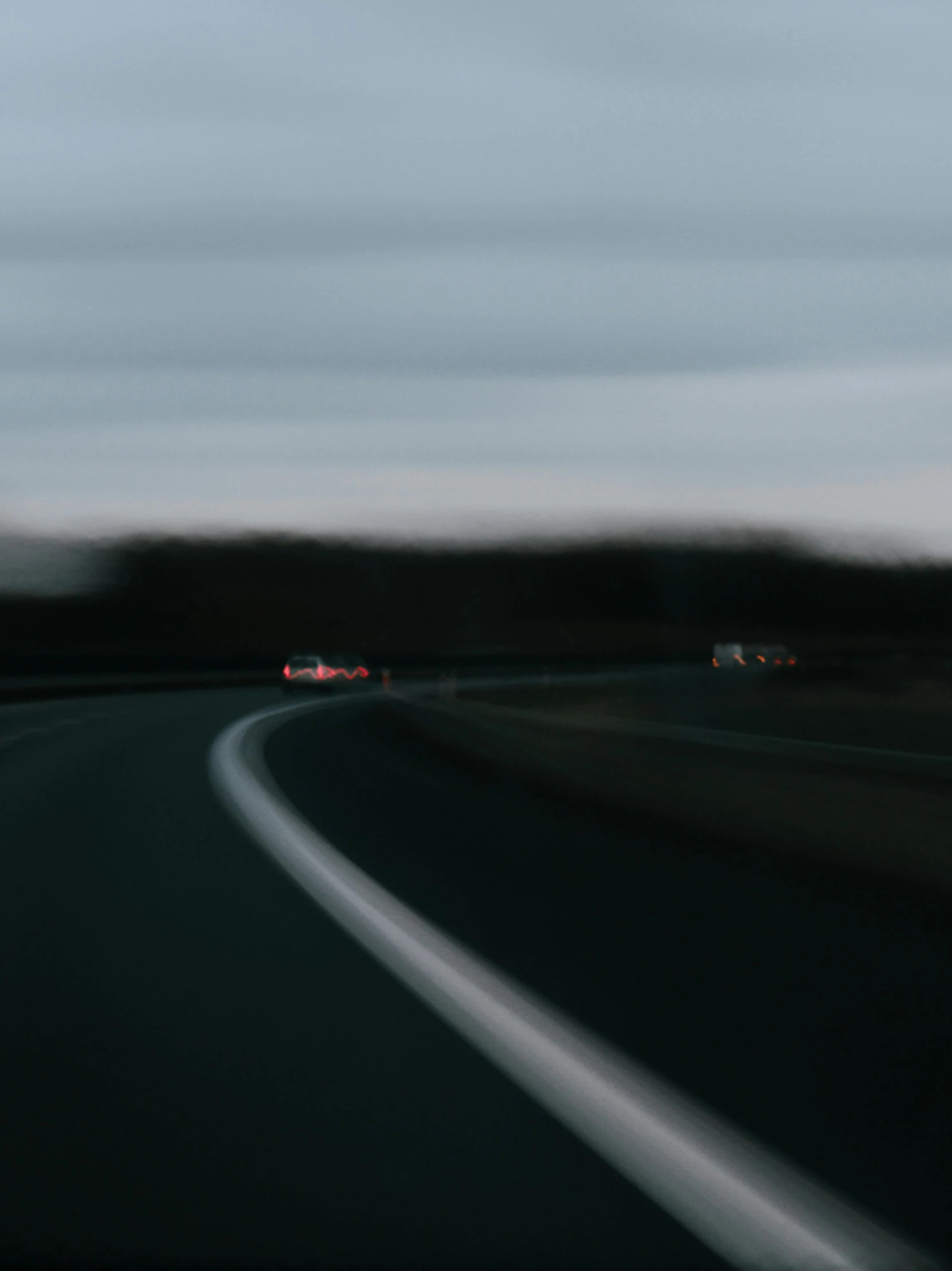 a blurry view of a road with two vehicles driving on it