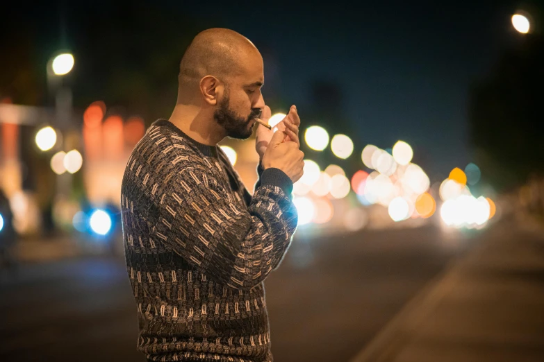 a man standing in the street in the middle of night talking on his phone