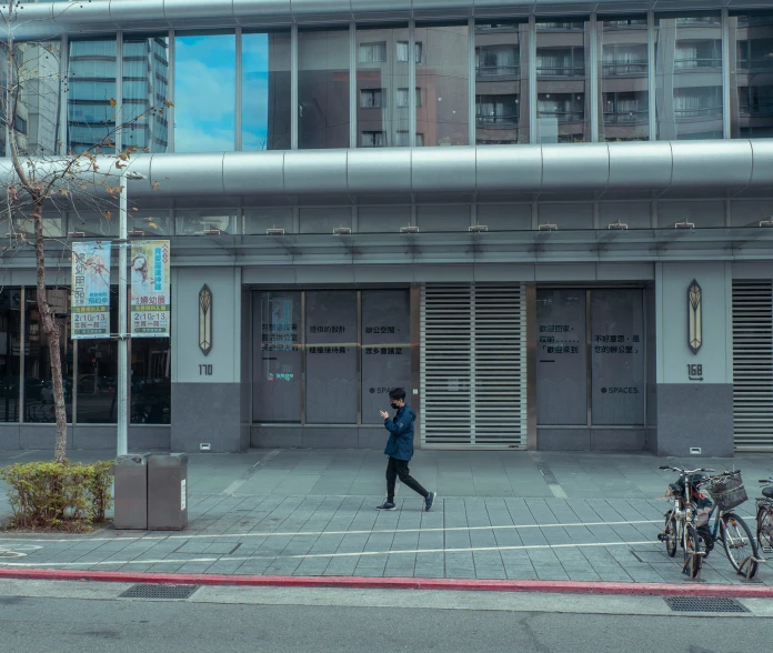 a man on a skateboard walking down the sidewalk