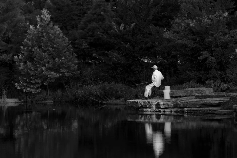 a black and white image of a man fishing