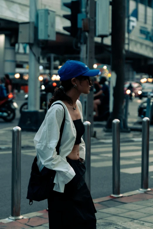 woman wearing blue hat walking down city street