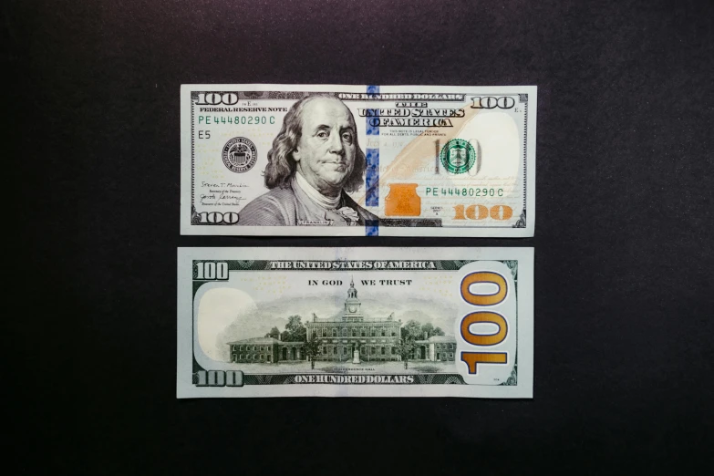 the two us dollar bills appear to be laying close together