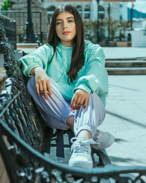 woman sitting on black bench near building in urban area