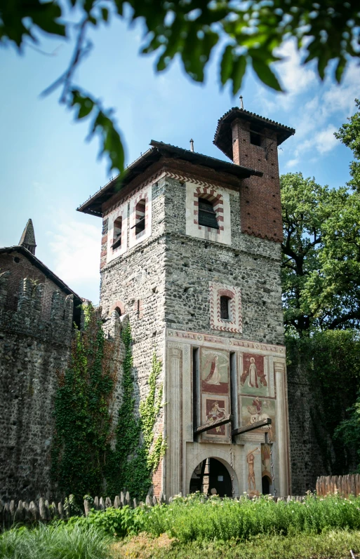 an old brick building surrounded by tall trees