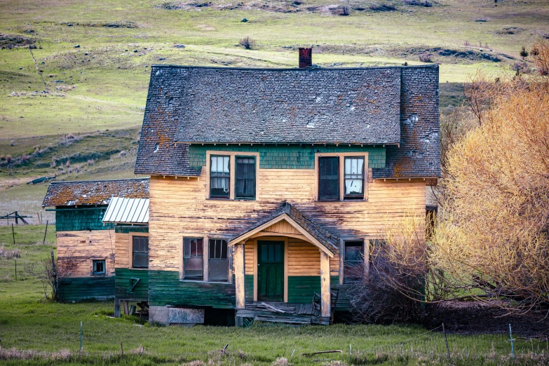 a old house sits on the side of a hill