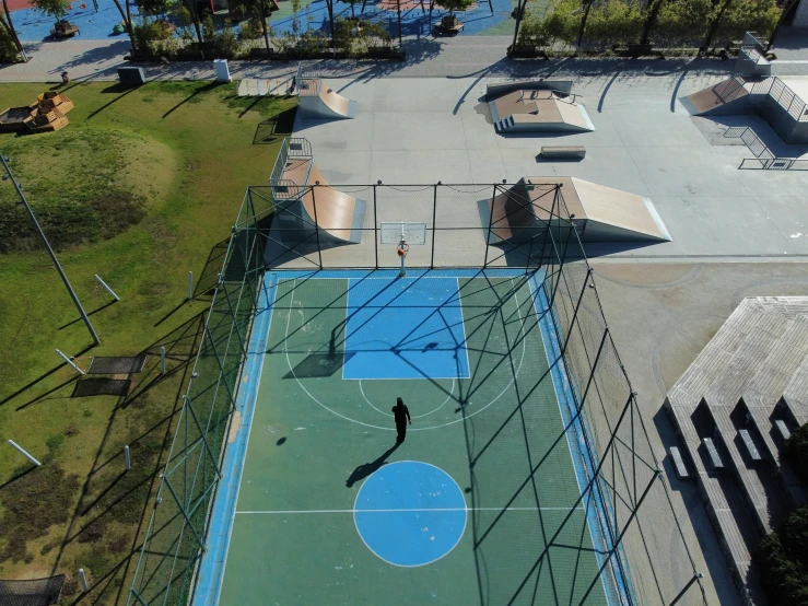 a man is playing basketball on a field in the middle of an empty court