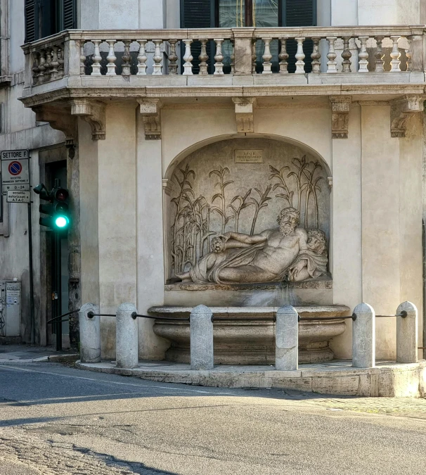 a statue is at the end of the sidewalk by a building