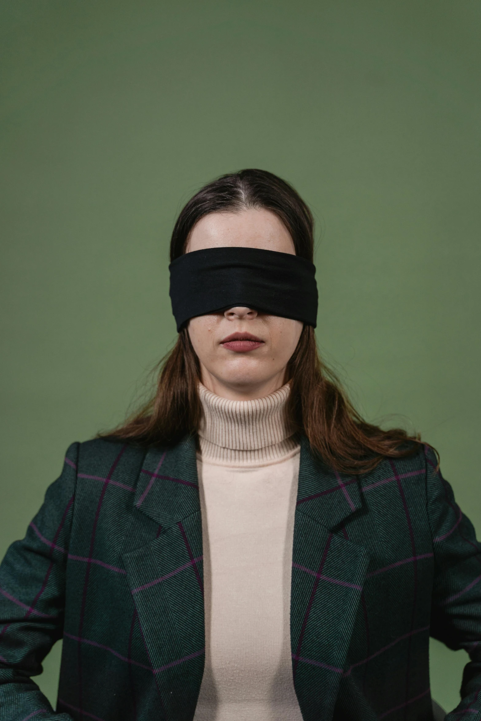 a woman is holding up her black blind behind her head