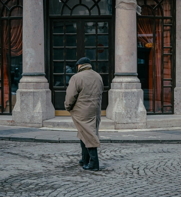 man with jacket, standing on a cobblestone street