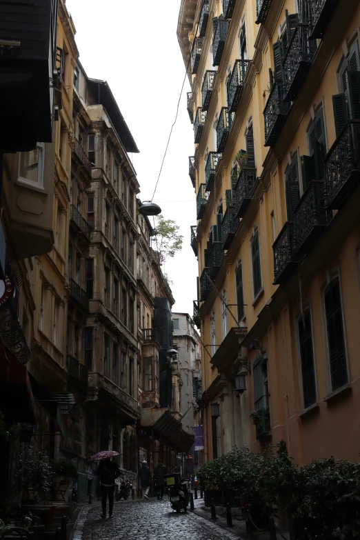 an alley with cobblestone and balconies in an urban setting