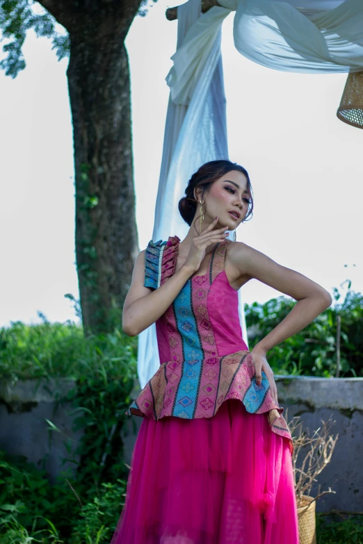 a woman posing in a dress and holding her hand on her chest