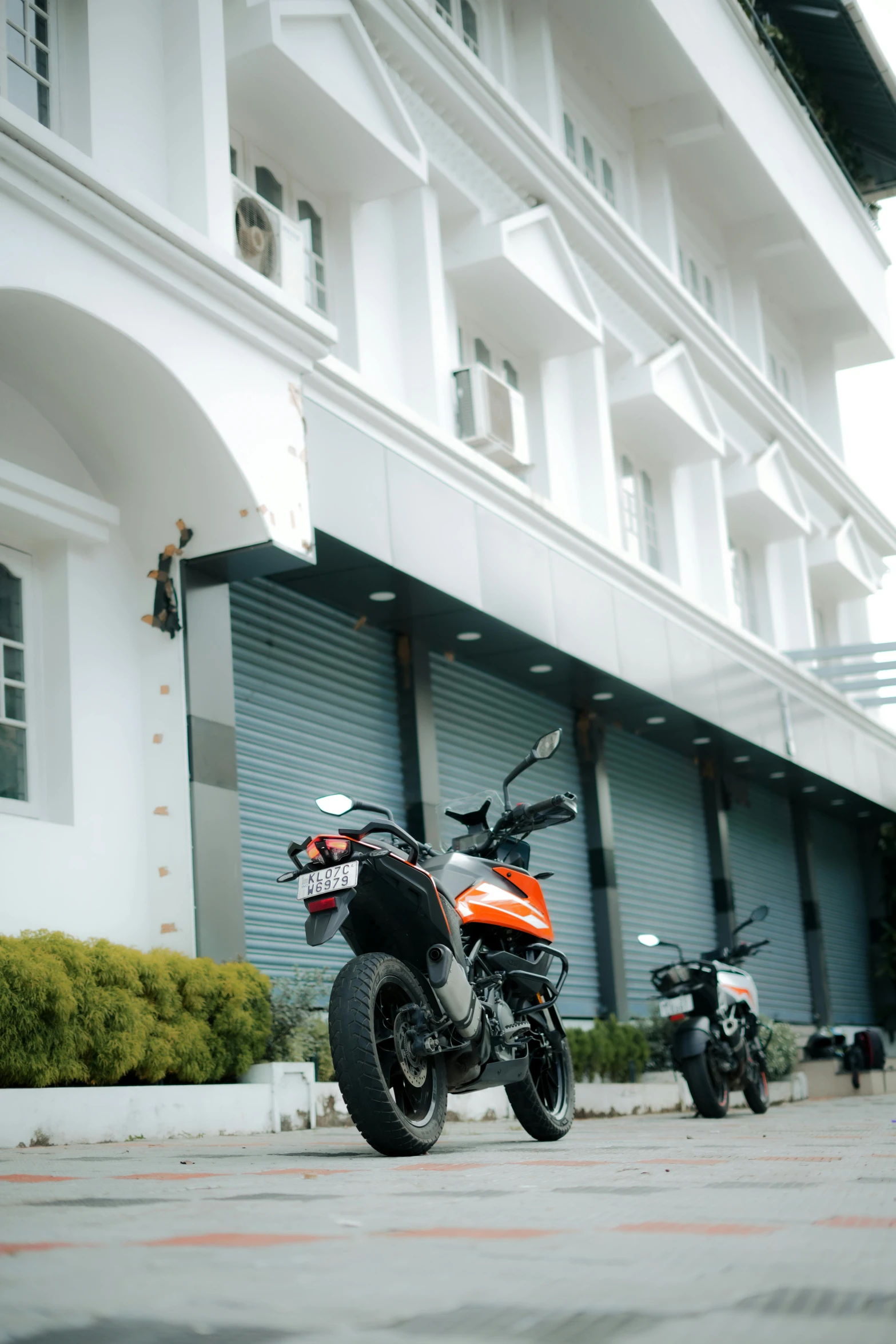 an orange motorcycle parked in front of some white building