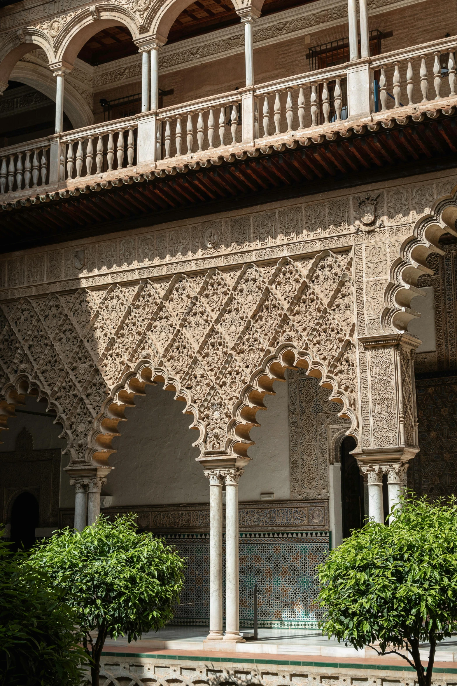 an intricate building with trees and a bench in front