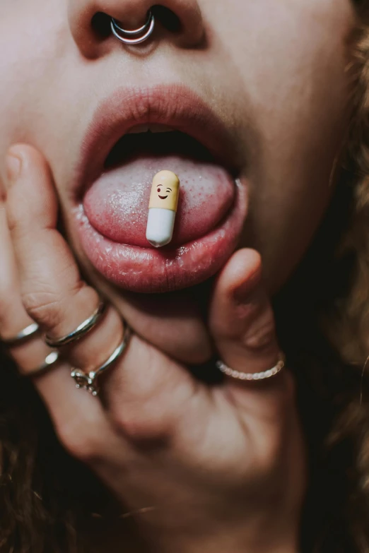 a woman holds an pill in front of her mouth