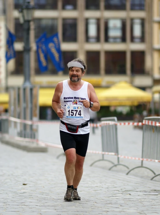 a man running down the middle of a cobblestone street