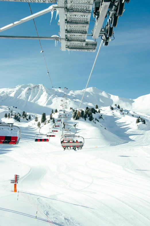 a ski lift with ski lifters and a skiier going down the hill