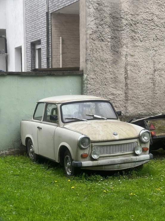 an old car with a white hood is on the grass
