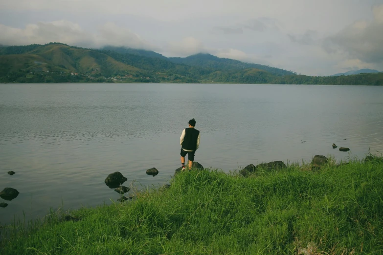 a person on the shore of a large lake