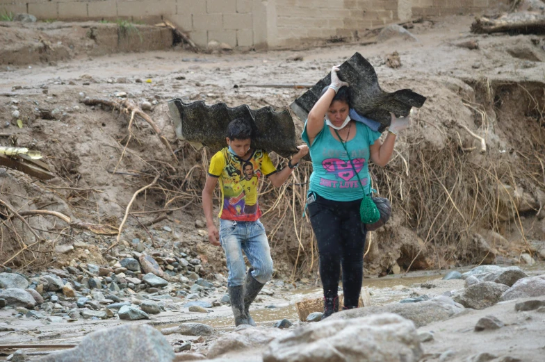 there are two people standing near rocks walking together