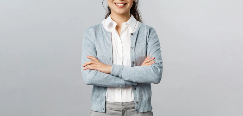 smiling woman standing with her arms crossed