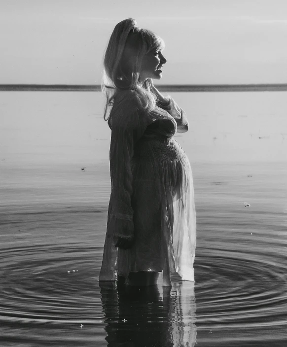 a woman standing on the side of a large body of water