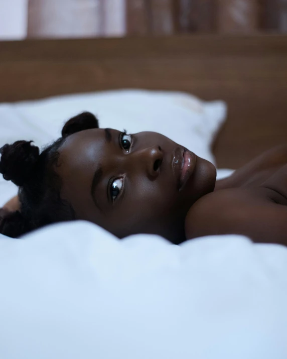 a close up of a woman laying on a bed