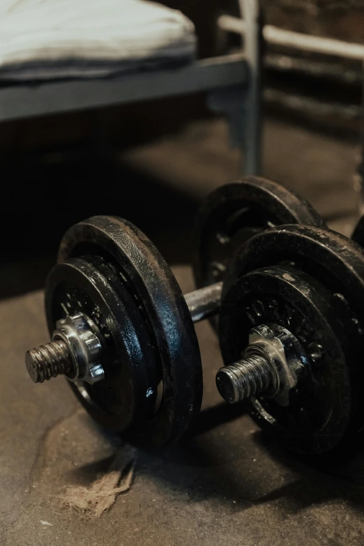 two dumbbells laying on the ground in front of a mattress
