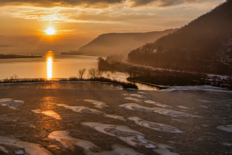 the sun is shining down over the water with mountains in the background