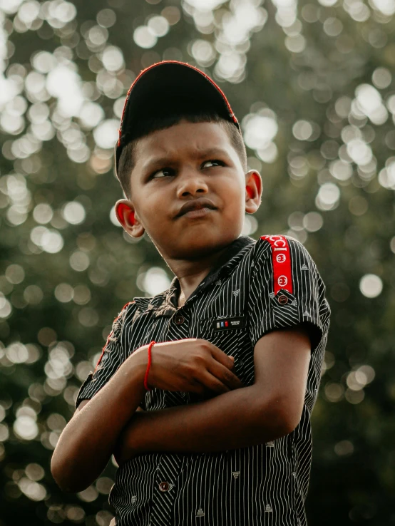 an african boy with short black hair and red and white striped shirt