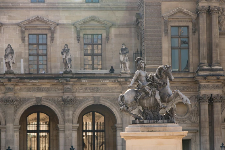 the statue is in front of a large building