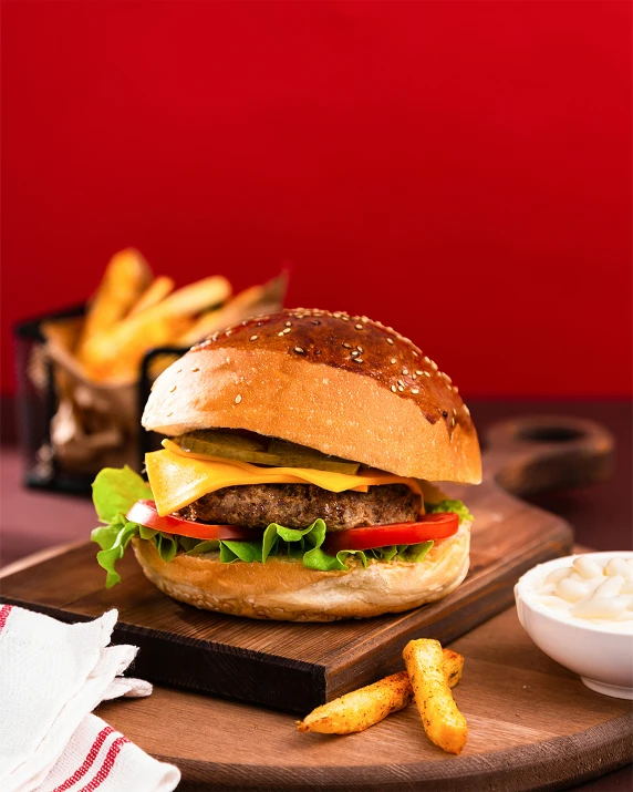 a big cheeseburger and fries in the foreground