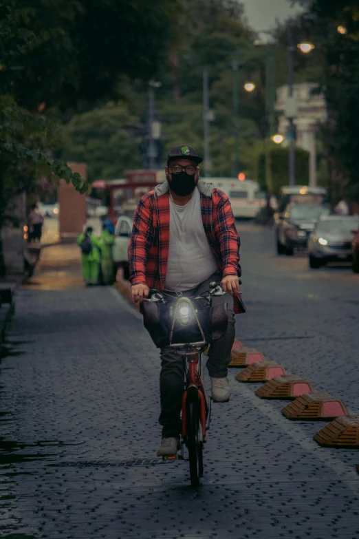 a man riding a bike with a big face mask on it