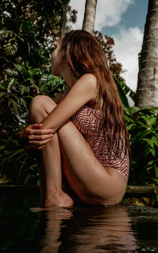 a girl sitting on the ground with her knees crossed