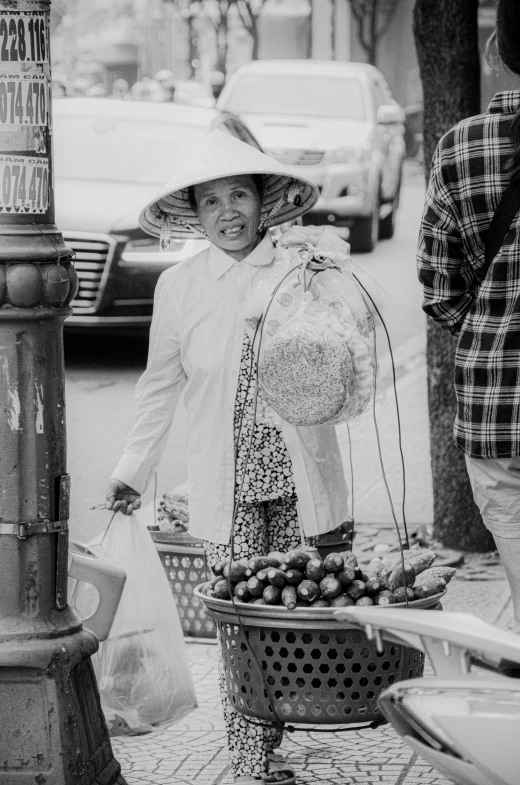 a person standing on the sidewalk carrying bags