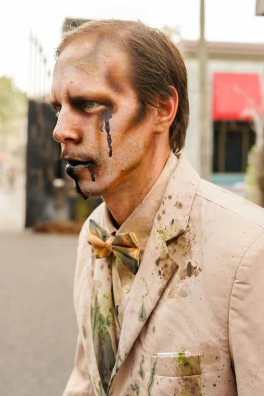 a man wearing muddy makeup and a suit coat