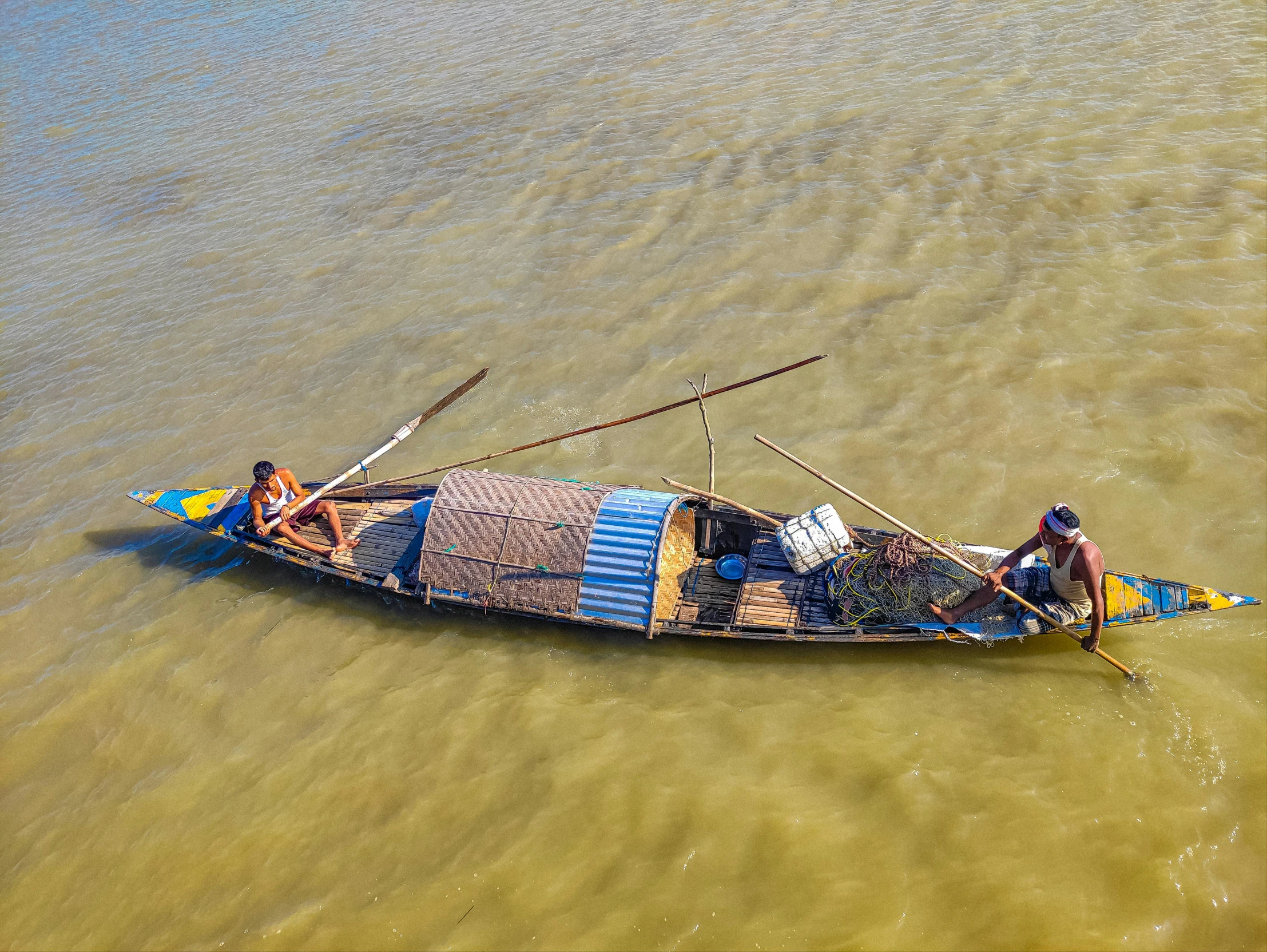 a small boat with two people in the water