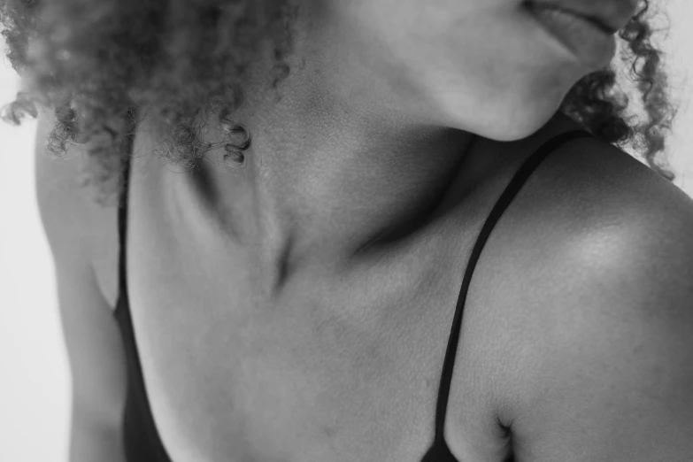 a woman with natural curly hair wearing a black halter