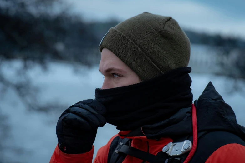 a man is wearing a neck gaiter in the snow