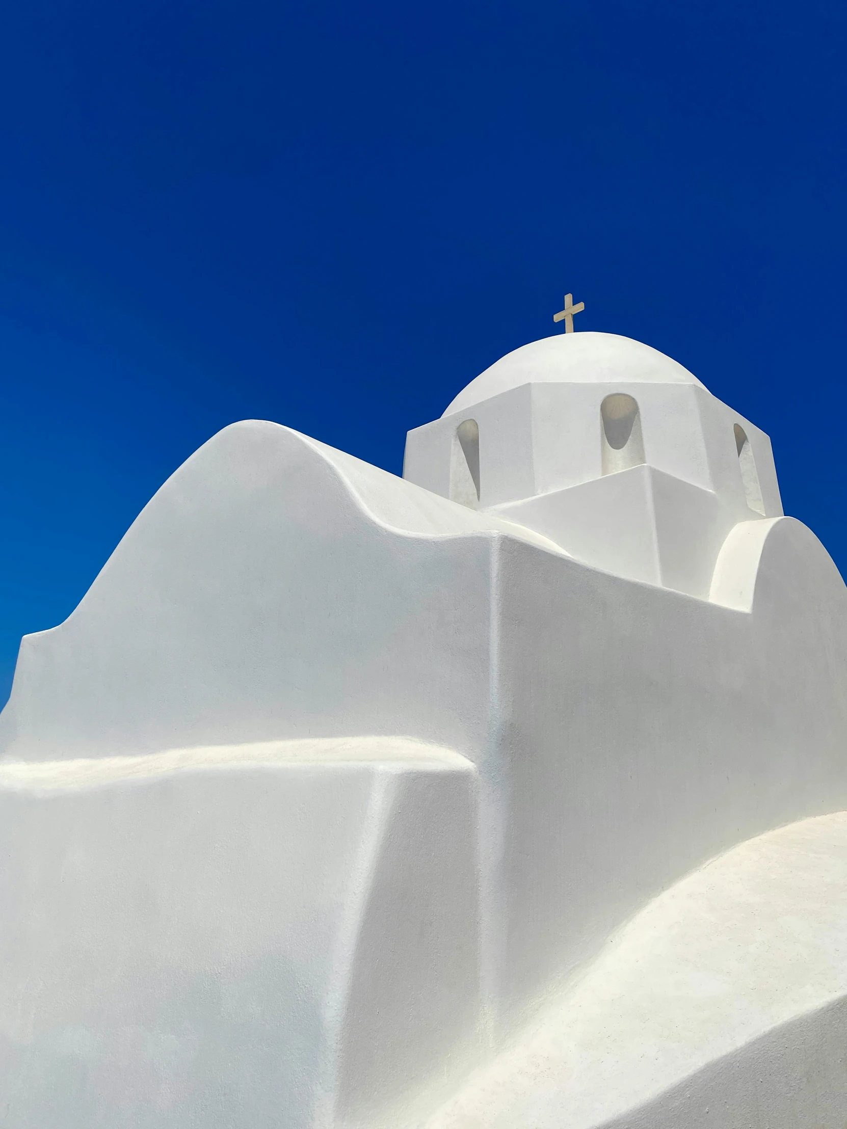 the side of a white church with a cross atop