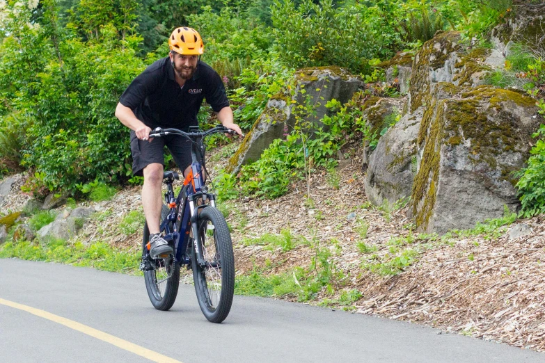 a man is riding a bike down a road in the woods