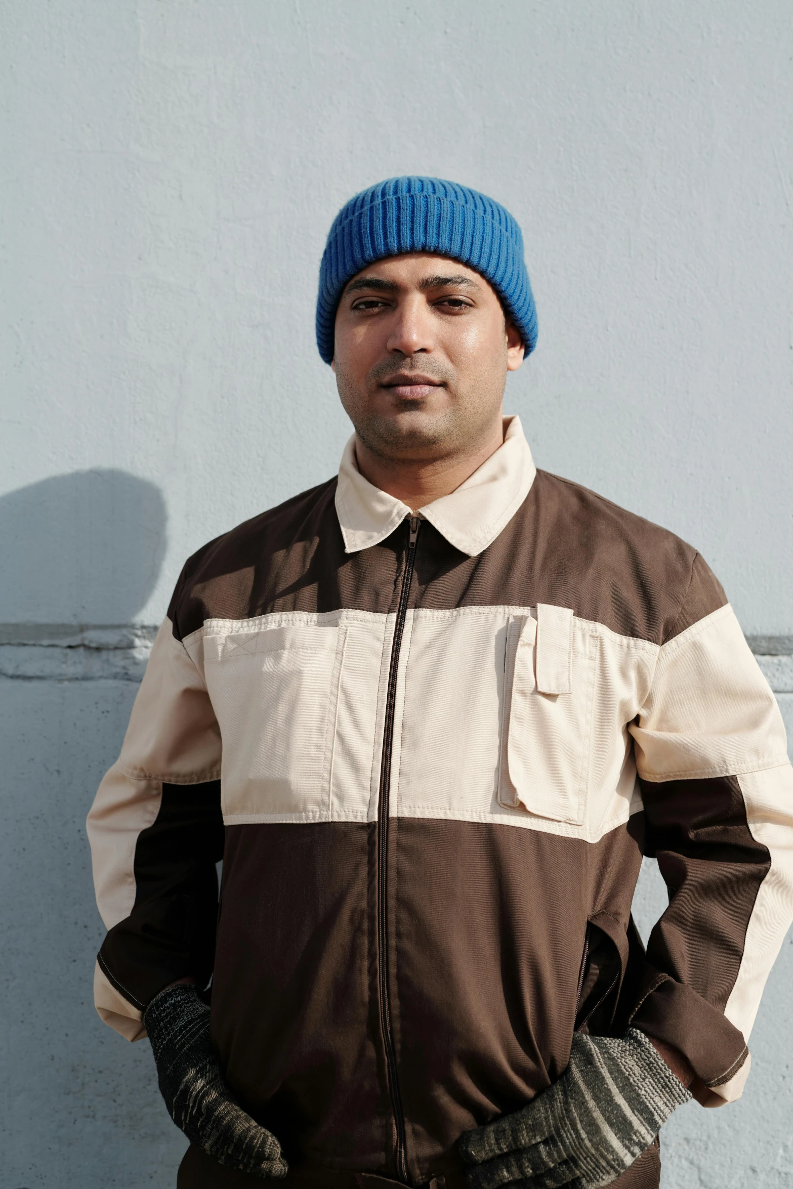 man in a blue hat standing on the street