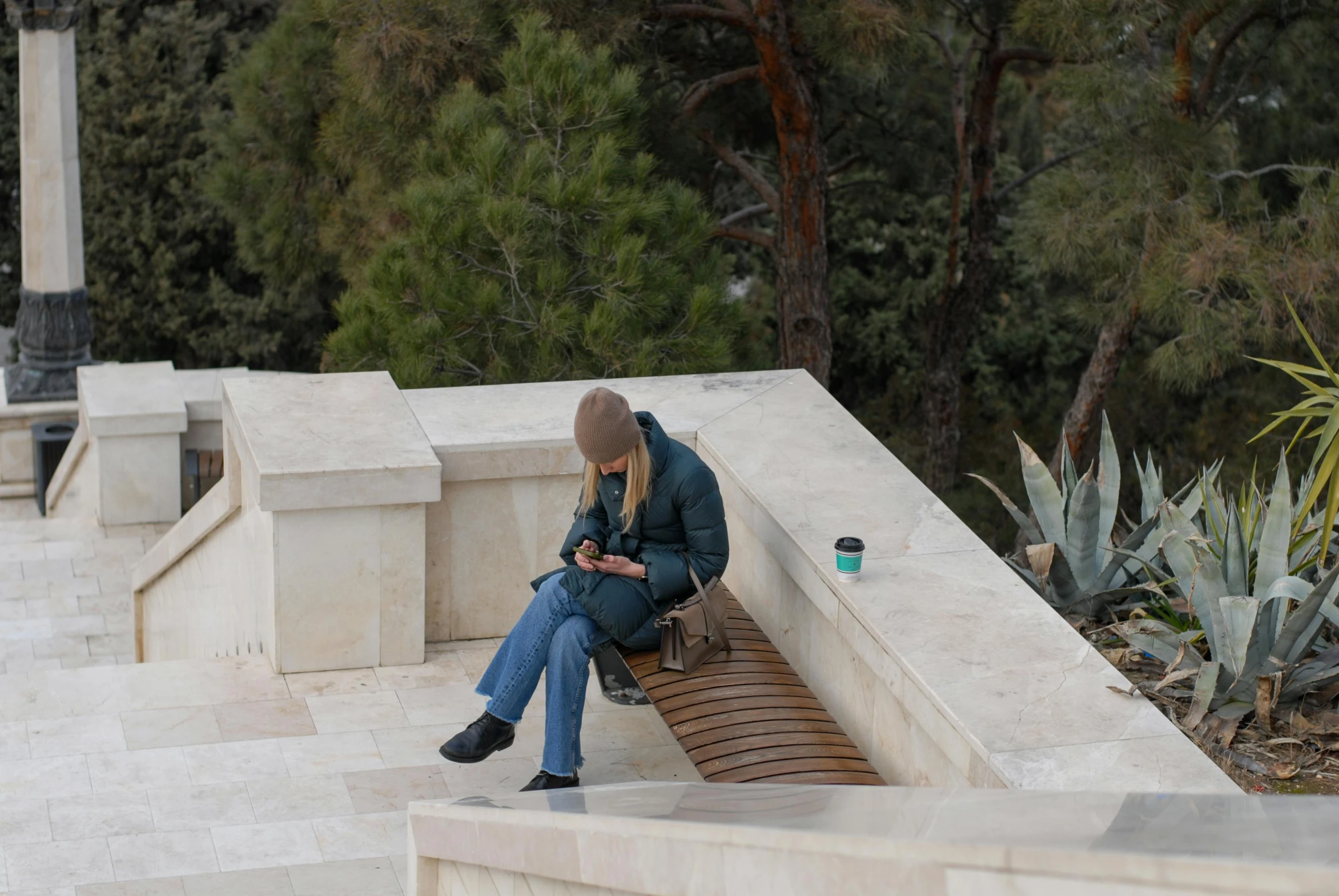 there is a woman sitting on a bench with a phone