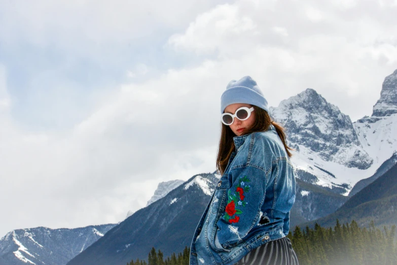 a woman is standing on a snow covered mountain