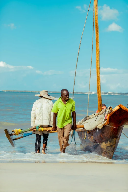 two men carrying items in a boat at the beach