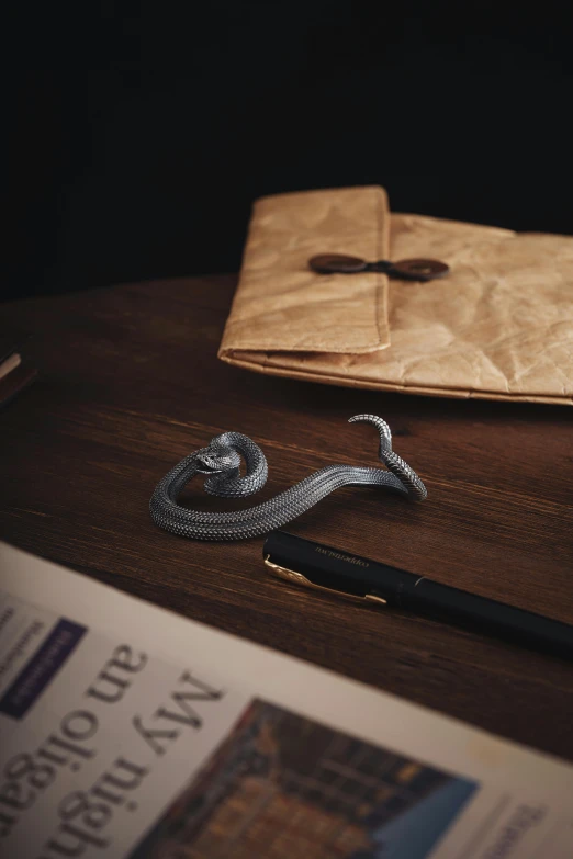 a pen on a wooden table near a paper bag