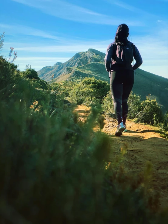 a person is hiking down a hill on a sunny day