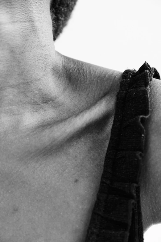 the back of a man's neck with a black tie hanging on it